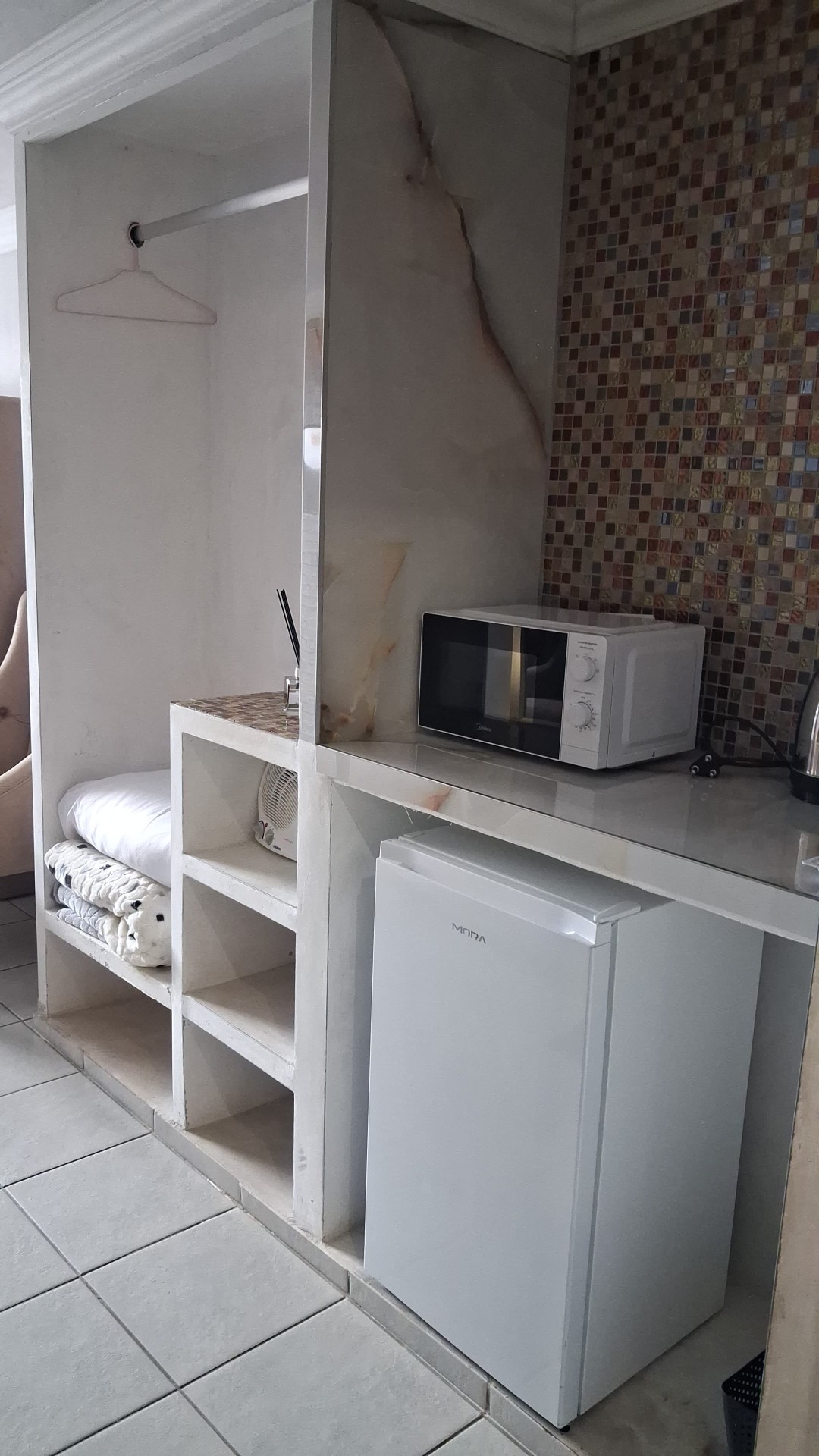 Kitchenette with mini fridge, microwave, mosaic tiles and shelving