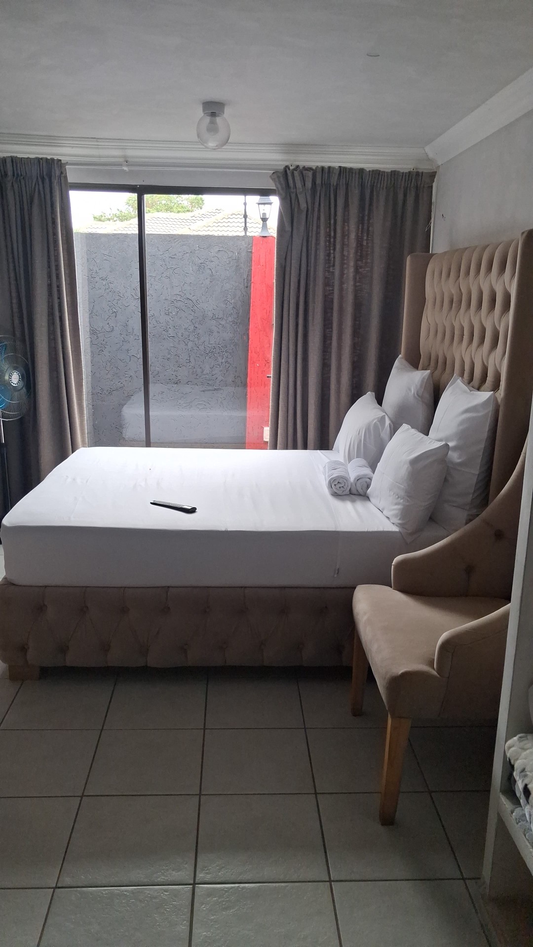 Beige tufted headboard suite with sliding door and tiled floor