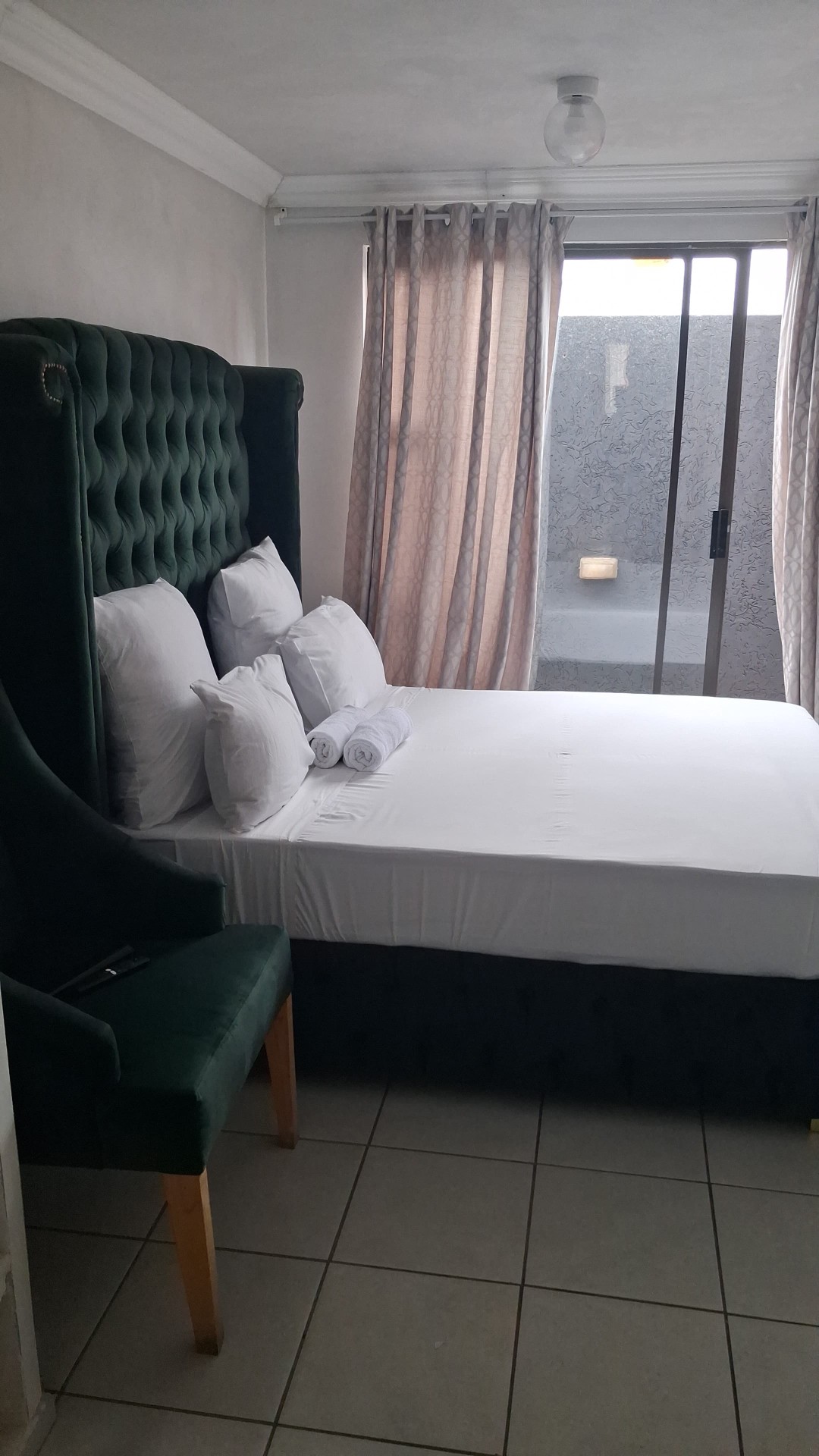 Green tufted headboard bedroom with sliding door